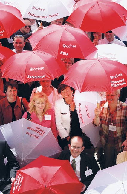 Mit roten und weißen Regenschirmen, auf denen bestimmte seltene Erkrankungen...