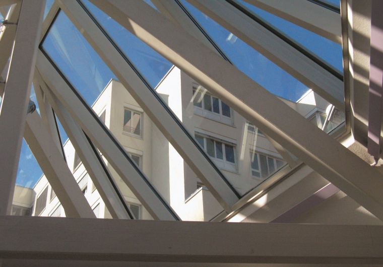 Blick auf den neu sanierten Pflegetrakt durch ein Glasdach der Kinderklinik