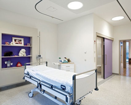 In den Patientenzimmern ist die Medizintechnik in Möbeln, Decken und Wänden...