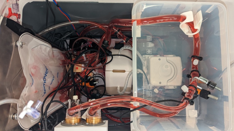 Blick in das Innenleben der Box. Die Schläuche sind mit einer roten...