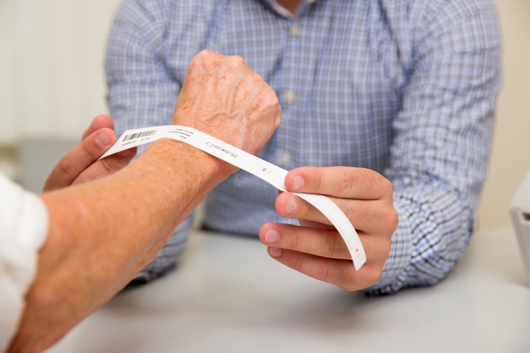 Bei der Aufnahme eines Patienten wird über den Armilla-Armbanddrucker ein...