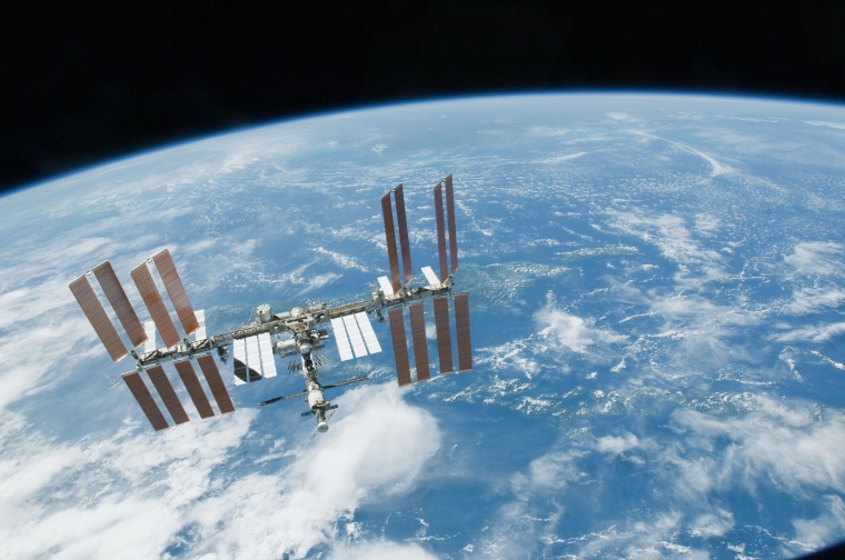 ISS backdropped by a blue and white part of Earth