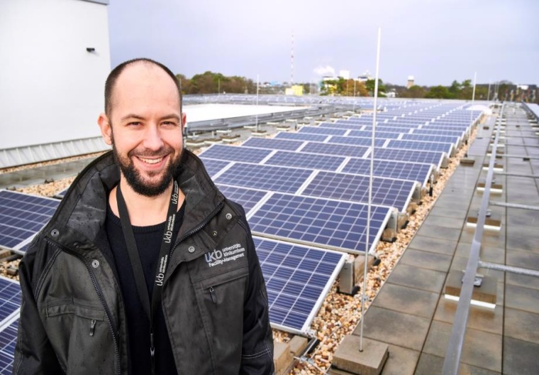 Klimamanager Marcel Malucha vor der Photovoltaikanlage auf dem Dach des...