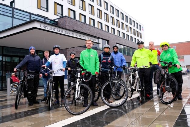 Start der Radtour bei Regen vor Haus C am Campus Kiel: Phil Ladehof (Mitte, in...