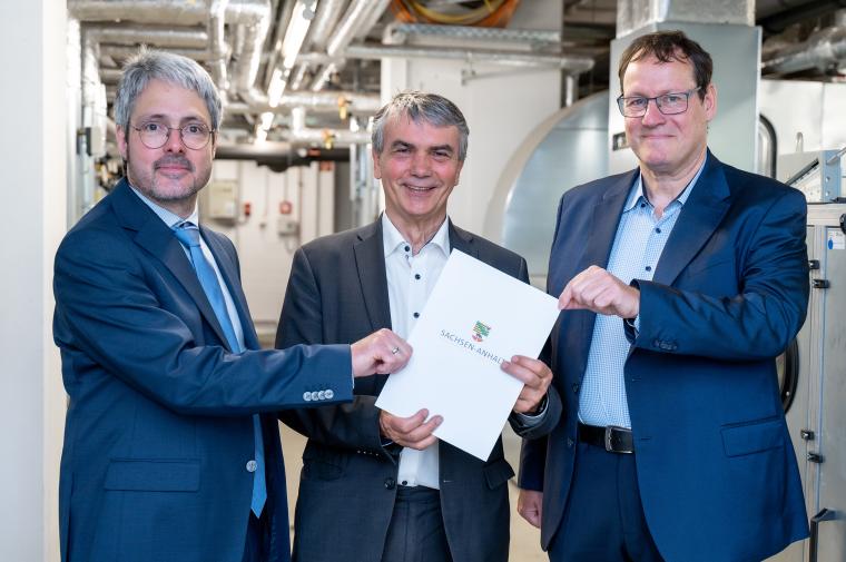 Staatssekretär Dr. Steffen Eichner (Mitte) übergibt Dr. Felix Glahn (links)...