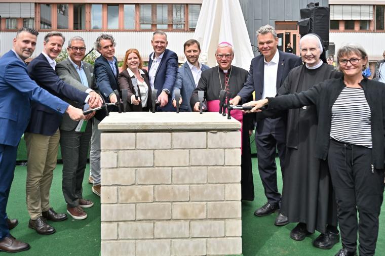 Zehn „Hammer-Heldinnen und -helden“ schlagen mit Hämmern symbolisch auf...
