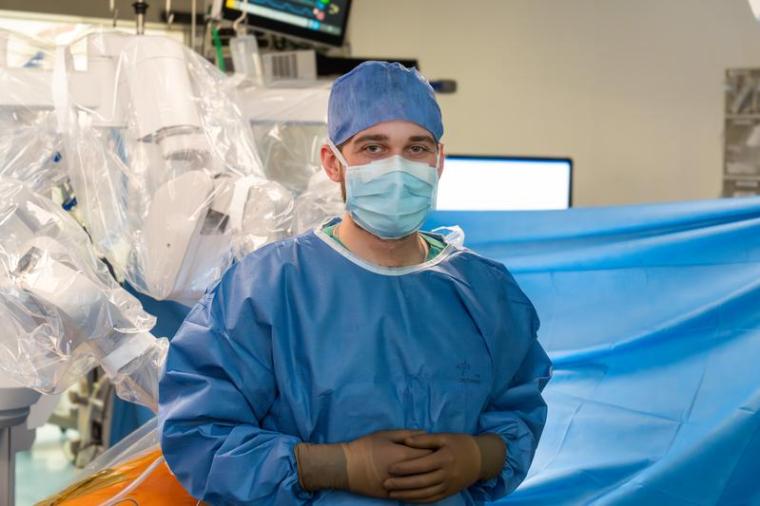 Dr. Julius Kaemmel vor einem Operationsroboter der Klinik für Herz-, Thorax-...
